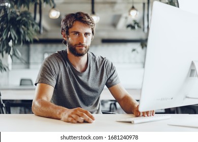 Bearded man freelancer using computer in a modern coworking place. Freelance business concept - Shutterstock ID 1681240978