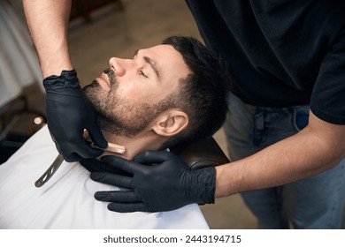 Bearded man getting beard haircut by barber at barbershop - Powered by Shutterstock