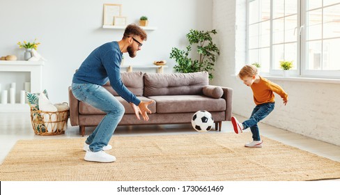 Bearded Man In Glasses  Catching Ball While Teaching Boy To Play Football In Cozy Room At Home
