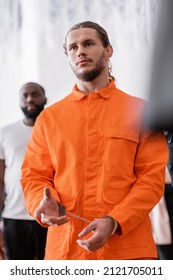 Bearded Man In Handcuffs And Orange Jail Uniform Gesturing In Courtroom