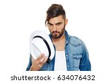 Bearded man with a hat posing in the studio