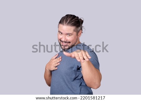 A bearded man in his 30s blushes, reacting to a compliment in a funny way. Feeling a bit bashful. Stock photo © 