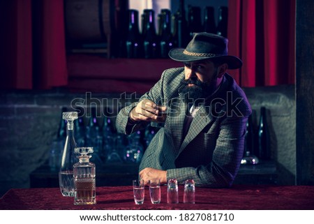 Bearded man holding glass of a whiskey