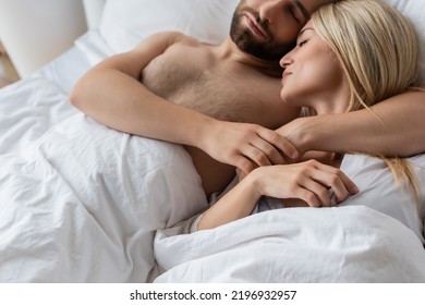 Bearded Man Hugging Blonde Girlfriend While Sleeping On Bed At Home