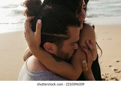 Bearded Man Kissing Hand On Happy Woman With Tattoo On Beach