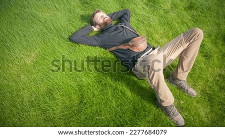 Bearded man laying down in a lawn