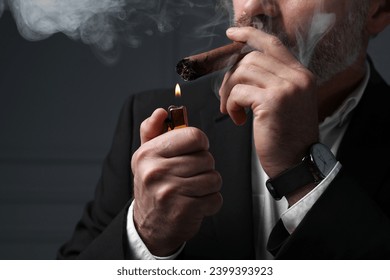 Bearded man lighting cigar on dark grey background, closeup - Powered by Shutterstock