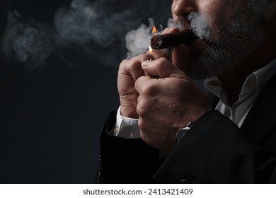 Bearded man lighting cigar on dark grey background, closeup. Space for text - Powered by Shutterstock