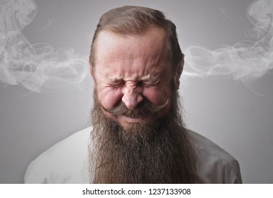 Bearded man looking angry.