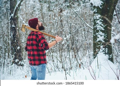 Bearded man. Lumberjack in winter snowy forest. Bearded hipster with axe. Serious lumberjack on winter day outdoors. Lumberjack lifestyle. Handsome man working in forest.