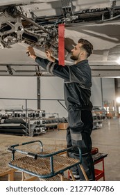 Bearded man maintenance technician tightening bolt with wrench while repairing aircraft in hangar