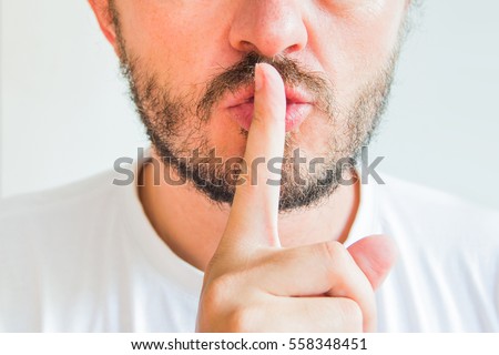 Bearded man making silence gesture, pst, shh, face detail