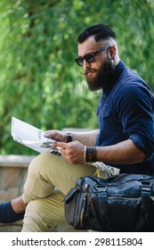 bearded man with a map in hand looking away