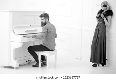 Bearded man in mustard yellow shirt playing piano while pretty girl in twenties dress and fur collar leaning on wall isolated on white background. - Powered by Shutterstock