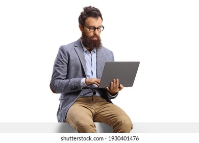 Bearded Man With On A Laptop Sitting On A Panel Isolated On White Background