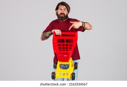 Bearded Man Pointing With Finger On Empty Shopping Cart. Sale. Discount. Black Friday. Buying Spree.