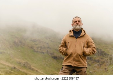 Bearded Man reaching the destination and on the top of mountain at sunset on autumn day Travel Lifestyle concept The national park Lake District in England