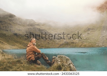 Bearded Man reaching the destination and on the top of mountain at sunset on autumn day Travel Lifestyle concept The national park Lake District in England