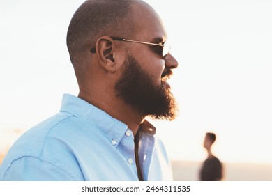 Bearded man sending text message via mobile telephone chatting online while enjoying summer evening, hipster guy satisfied with 4G connection in roaming share photos from vacation in social networks