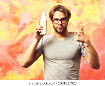 Bearded Man, Short Beard. Caucasian Sexy Serious Macho With Moustache In Glasses Wearing Gray Shirt Holding Plastic Bottle Of Milk On Colorful Studio Background