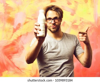 Bearded Man, Short Beard. Caucasian Sexy Satisfied Macho With Moustache In Glasses Wearing Gray Shirt Holding Plastic Bottle Of Milk On Colorful Studio Background