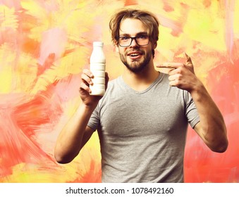 Bearded Man, Short Beard. Caucasian Sexy Amused Macho With Moustache In Glasses Wearing Gray Shirt Holding Plastic Bottle Of Milk On Colorful Studio Background