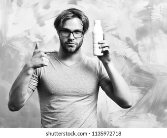 Bearded Man, Short Beard. Caucasian Sexy Serious Macho With Moustache In Glasses Wearing Gray Shirt Holding Plastic Bottle Of Milk On Colorful Studio Background