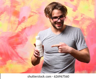 Bearded Man, Short Beard. Caucasian Sexy Amused Macho With Moustache In Glasses Wearing Gray Shirt Holding Plastic Bottle Of Milk On Colorful Studio Background