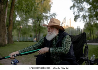 A bearded man sits comfortably in a chair, holding a fishing rod - Powered by Shutterstock