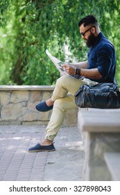 bearded man sitting and looking at a map