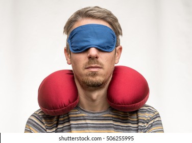 Bearded Man With Sleeping Mask And Red Travel Pillow On White Background