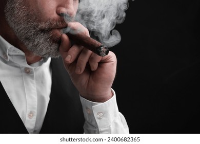 Bearded man smoking cigar against black background, closeup. Space for text - Powered by Shutterstock