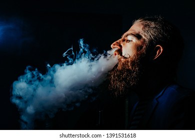 bearded man smoking a hookah in a dark room. hookah lifestyle and smoking concept. portrait of a sailor with a hookah close up. Toned image
