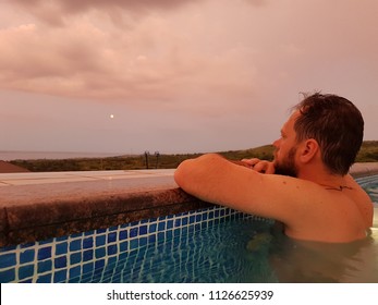 A Bearded Man Is Swimming In An Outdoor Pool At Sunset On A Summer Vacation. Video Taken On Mobile Phone