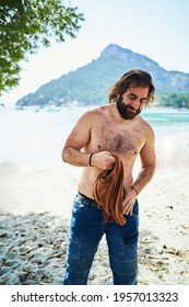 Bearded Man Taking Off Shirt Before Taking Bath On Beach. Summer Concept