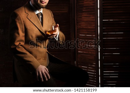 Bearded man taste alchohol drink in luxury interior