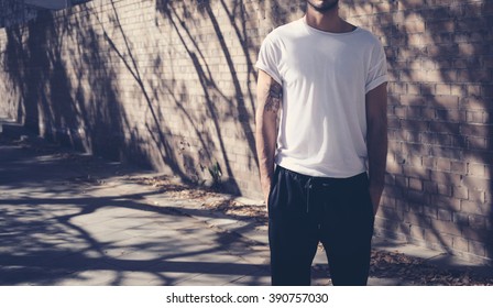 Bearded Man With Tattoo Wearing Blank White Tshirt And Black Sunglasses. City Street Background. Horizontal Mockup