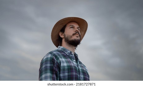 Bearded Man Wearing Plaid Shirt Holding Spikelet, Reed, Dry Grass His Mouth And Looking At The Sky