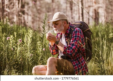 Bearded mature man smoking medical marijuana in nature. 