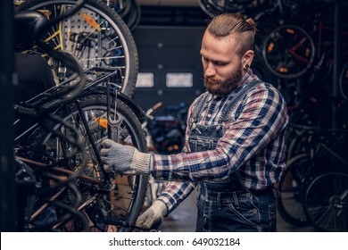 Bearded mechanic doing bicycle wheel service manual in a workshop. - Powered by Shutterstock