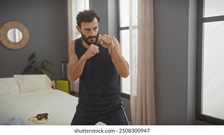 Bearded middle-aged man shadowboxing in a modern bedroom, showing fitness and athleticism at home. - Powered by Shutterstock