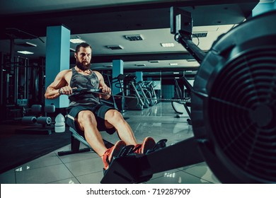 Bearded Muscular Fit Man Ssing Rowing Machine at Functional Training Gym