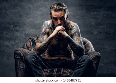 Bearded sad man is sitting in old armchair at abandoned house alone and thinking about his life. - Shutterstock ID 1488487931