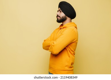 Bearded South Asian Man Wearing Turban Posing With Arms Crossed Isolated Over Yellow Wall