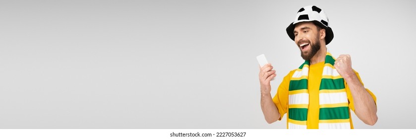 bearded sports fan watching football match on smartphone and rejoicing isolated on grey, banner - Shutterstock ID 2227053627