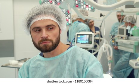 Bearded Surgeon Thinking About Some Problem At The Surgery Room. Close Up Of Male Medical Worker Having Sad Face. Middle Aged Caucasian Man In Medical Uniform Looking Tired After Surgery