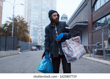 Bearded tramp man with bag on city street - Shutterstock ID 1625807719