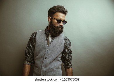 Bearded young businessman posing with sunglasses 