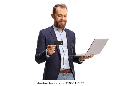 Bearded Young Man Looking At A Credit Card And Holding A Laptop Computer Isolated On White Background