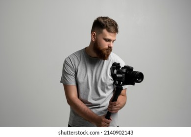 Bearder videographer filmmaker cinematographer dop with 3-axis gimbal and dslr camera. Filmmaking, videography, hobby and creativity concept.